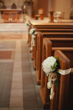 flowers are tied to pews in a church