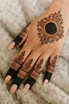 a woman's hand with henna tattoos on it