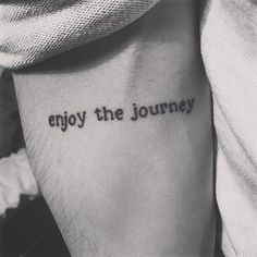 a tattoo saying enjoy the journey on someone's arm