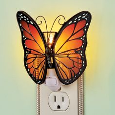 a light that is on the side of a wall with a butterfly lamp attached to it