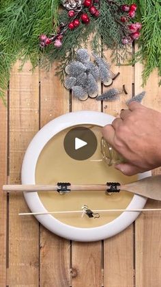 a person is using a knife to cut something on a plate with christmas decorations in the background