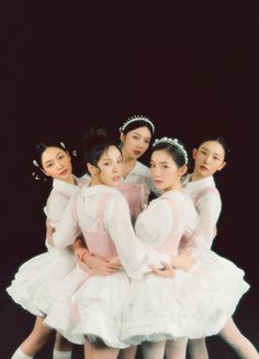 five young ballerinas in white tutus posing for a photo with their arms around each other