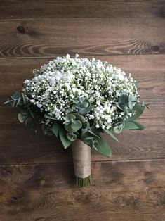 a bouquet of white flowers sitting on top of a wooden floor