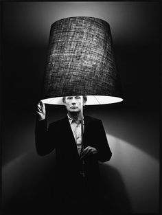 a woman holding a lamp up to her face