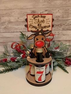 a bottle of beer sitting on top of a wooden stand next to a christmas tree