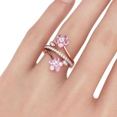 Elegant and beautiful,this flower ring will capture your heart at first sight! Flower is one of the most popular design elements in jewelry. We hope you will like our flower ring. Crafted in rose gold tone sterling silver, sculptured in two lively flowers, the ring is a masterpiece. Every blossom is set with fancy pink stone as petals and linked with a high polished bypassing ribbon. The branch and leaves of the ring is set with white stones to complement the design and add sparkle to it. Treat yourself a holiday gift with this masterpiece!Carat Weight: 3.037 ctStone Size: 1.5,3,3 mmStone Type: Jeulia® StoneNumber of Stones: 34 Stone Color: Diamond White, Fancy PinkStone Shape: RoundWeight: 4.52 gWidth: 2.62 mmHeight: 6 mmThickness: 1.52 mmMaterial: 925 SilverPlating Color: Rose Gold Pink Sapphire Engagement Ring Rose Gold, Sapphire Engagement Ring Rose Gold, Opal Birthstone Ring, Gold Flower Design, Pink Sapphire Engagement Ring, Pink Sapphire Ring Engagement, Flower Rings, Rose Gold Flower, Engagement Ring Rose Gold