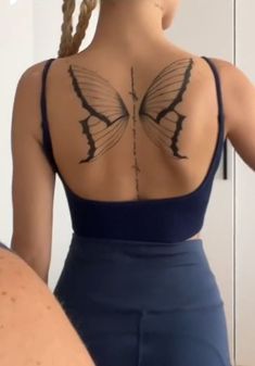 the back of a woman's body with tattoos on it