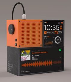 an orange and black radio sitting on top of a gray table next to a clock