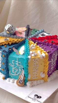 a birthday cake decorated with colorful frosting and decorations on top of a white table