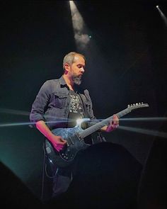 a man playing an electric guitar on stage