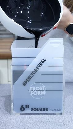 a person pouring liquid into a container on top of a counter