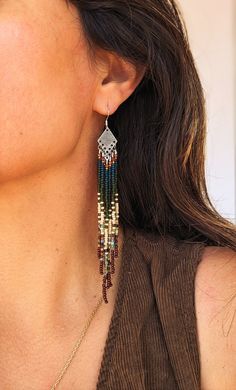 a close up of a person wearing some kind of earring with beads on it