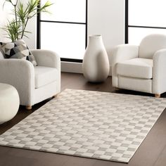 a living room with two white chairs and a large rug in front of the window