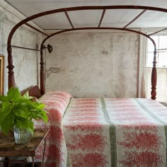 a bed in a bedroom with a wooden headboard and canopy over it's head