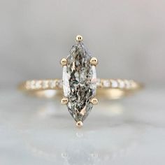 an engagement ring with a pear shaped diamond