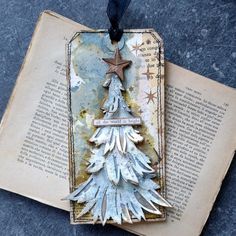 a bookmark with a christmas tree on it sitting on top of an open book