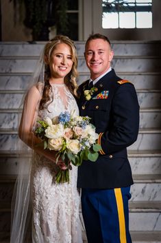 a bride and groom pose for a photo in front of the stairs at their wedding