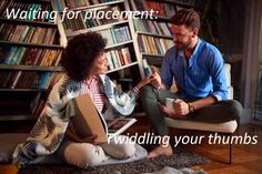 a man and woman sitting on the floor in front of a bookshelf talking to each other