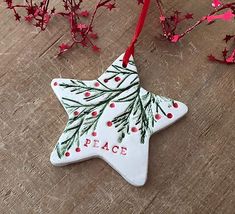 an ornament shaped like a star with the word peace painted on it