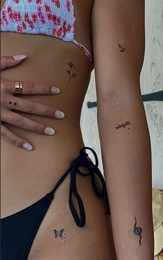 two women with tattoos on their stomachs and one has a small flower tattoo on her left side