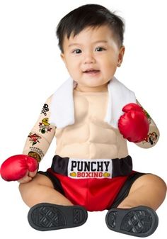 a baby sitting on the ground wearing boxing gloves