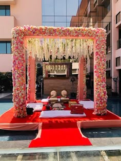 an outdoor ceremony setup with flowers and petals on the ground in front of a building