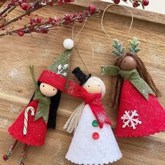 three ornaments are hanging on a wooden table