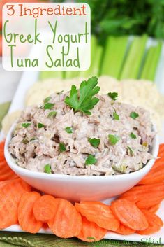 there is a bowl of tuna salad with carrots and celery on the side