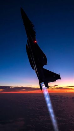 a jet flying through the air with a bright light on it's back end