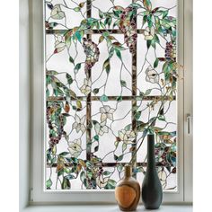 two vases sitting next to a window with stained glass panels on the windowsill