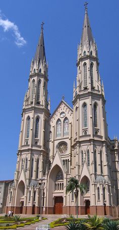 the large cathedral has two towers on it's sides and is surrounded by greenery