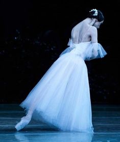 a woman in a white dress standing on a stage