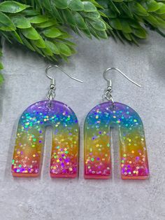 This rad collection of earrings are the perfect holiday gifts! The bar shaped pair drop to 2.25 inches, and the upside down U shape drop to 2.25 inches.  handcrafted by Elizabeth of Megabeth in the Midwest. Cheap Rainbow Teardrop Earrings, Handmade Rainbow Drop Earrings, Uv Resin Earrings, Rainbow Heart-shaped Earrings As Gift, Fun Multicolor Resin Earrings, Multicolor Resin Teardrop Earrings, Modern Hoop Earrings, The Upside, Glitter Earrings