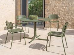 an outdoor table with four chairs around it