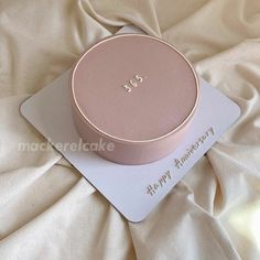 a pink box sitting on top of a white sheet