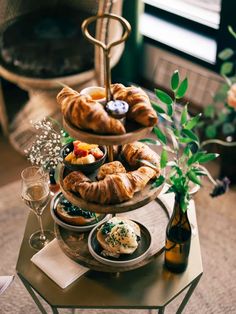 three tiered trays filled with pastries on top of a table next to a vase