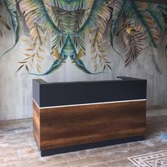 an office desk in front of a wall with leaves painted on the wall behind it