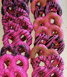 pink and black donuts with sprinkles on them