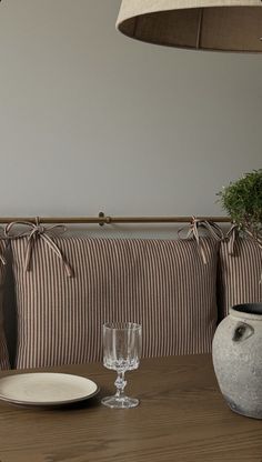 a table with plates and glasses on it next to a wall mounted planter in the corner