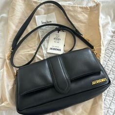 Like New. Not Used As A Daily Bag, Only Used A Few Times. Has Both A Shoulder And Crossbody Strap. No Scratches Or Discoloration. Edges Are In Perfect Condition. Only Slight Crease On Flap Where You Open Bag. In Great Condition Overall. Clean On Inside. Selling Bc Initially Bought It As A Daily Bag, But Found It Too Small For My Needs & Did Not Use Much. Beautiful Soft Black Leather With Gold Hardware. Tags Not Attached, But Have Dust Bag And Tag For It, Along With 2 Bag Straps. Have Original Receipt If Needed For Proof Of Purchase. Bag Now Retails For $1235, Purchased Last Year For $1145 Plus 8.5% Tax. Bags Jacquemus, Jacquemus Bags, Jacquemus Bag, My Needs, Daily Bag, Soft Black, Black Outfit, Bag Straps, Crossbody Strap