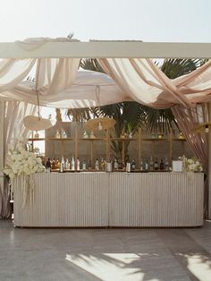 an outdoor bar set up with flowers and candles