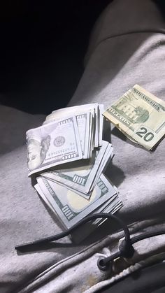 a pile of money sitting on top of a bed