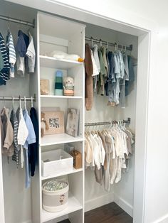 a white closet filled with lots of baby clothes and hanging railed shelves next to a wooden floor