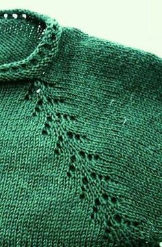 a green sweater with holes in the middle