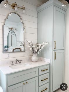 a white bathroom with marble counter tops and gold handles