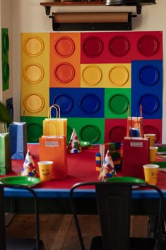 the table is set up for a birthday party with legos on it and colorful paper bags