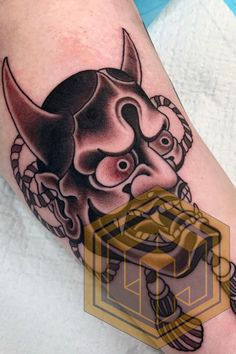 a tattoo on the leg of a person with a bull head and rope around it