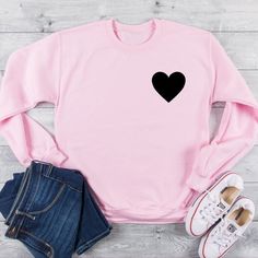 Womens Heart Shirt, Black Heart Sweatshirt, Heart Pullover, Black Heart Sweater, Heart Shirt, Gifts for Women, Casual Clothes, Pocket Heart••• HOW TO ORDER •••________________________1. Select the size and color of the shirt you would like to order.2. Add the quantity of shirt(s) you would like and then click "Add to Cart"3. Submit Order 4. During checkout please provide any additional information in the “Note to Seller” section. If you forget, just send me a message on Etsy after your order is Black Long Sleeve Tops With Heart Graphic, Black Long Sleeve Top With Heart Graphic, Black Heart Print Tops For Fall, Cute Black Crew Neck Sweater, Cotton Heart-shaped Top For Winter, Heart-shaped Cotton Winter Top, Trendy Cotton Sweater With Heart Graphic, Trendy Cotton Sweater With Heart Print, Casual Black Tops With Heart Print