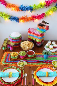 a table topped with plates and bowls filled with food next to a llama decoration