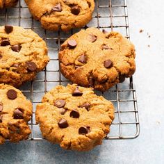 chocolate chip cookies on a cooling rack with one cookie broken in half and the other uncooked